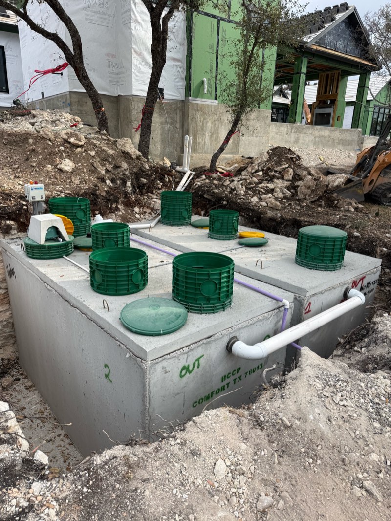Two aerobic septic tanks with green risers at a new home