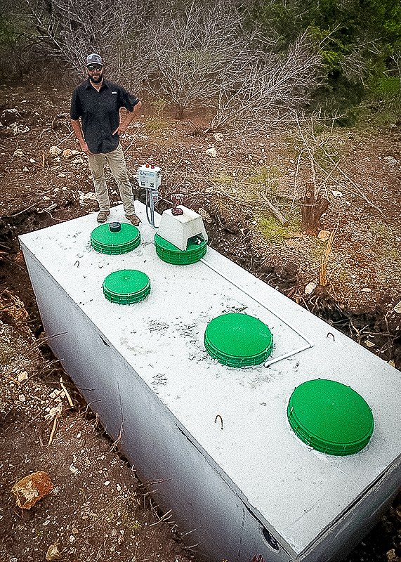 Member of the Varhol crew standing on a newly installed aerobic tank