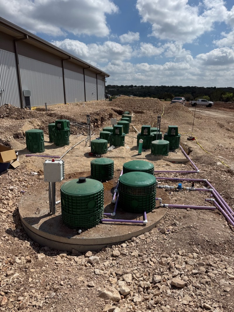 Commercial aerobic system with many tank risers next to a metal building