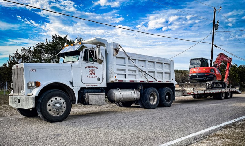 Dump truck hauling an excavator