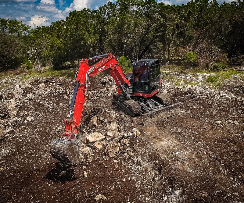 Excavator clearing rock