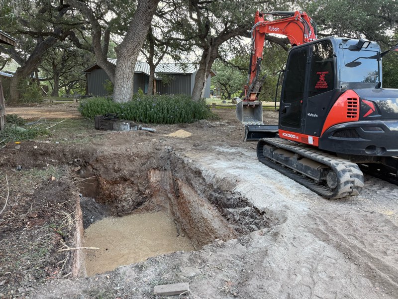 Excavator beside a dug pit