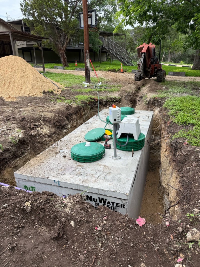Aerobic tank with control panel next to an older home